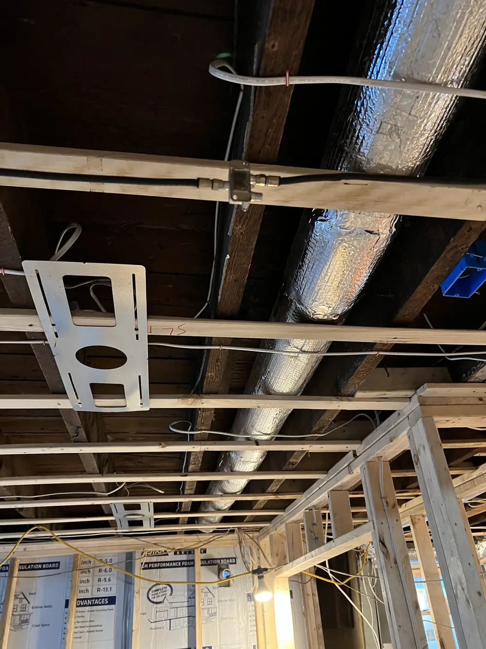 Insulated round duct and register boot support between floor joists