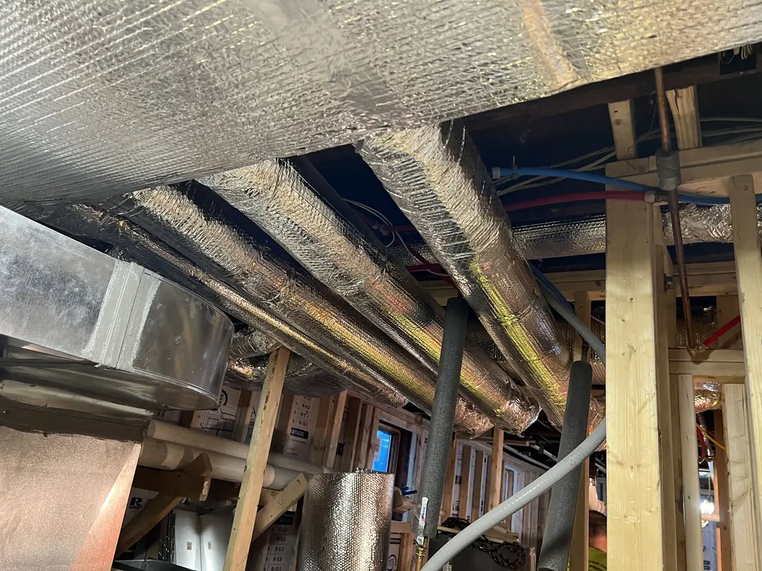 New sheet metal ductwork installed in a basement ceiling