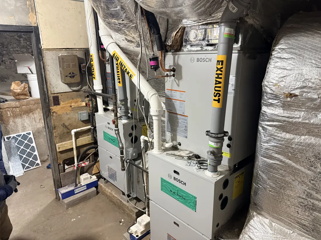 Technician servicing a gas furnace in a basement