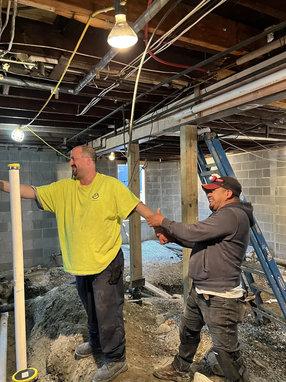 Priority One Services owner shaking hands with a crew member on a job site