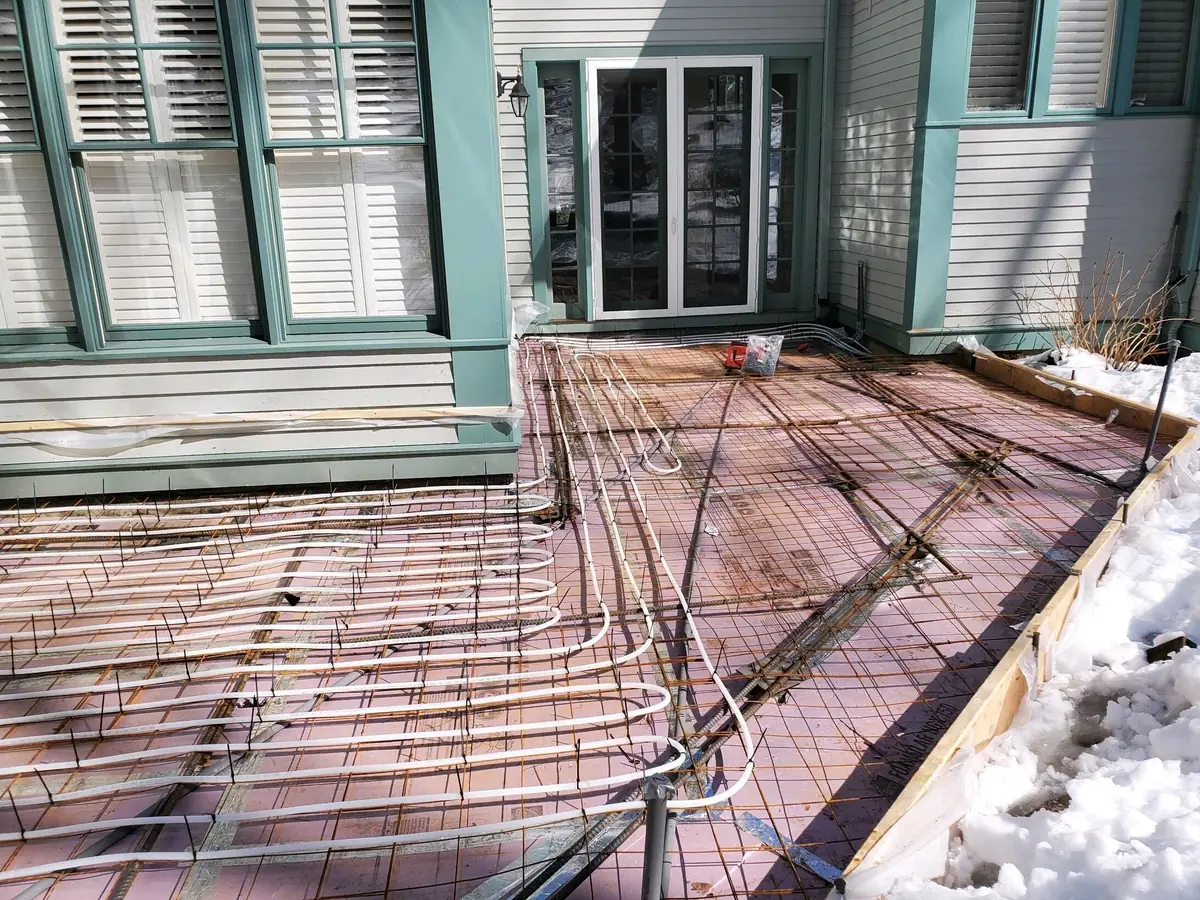 Radiant heating tubing laid out over insulation and rebar before a concrete pour